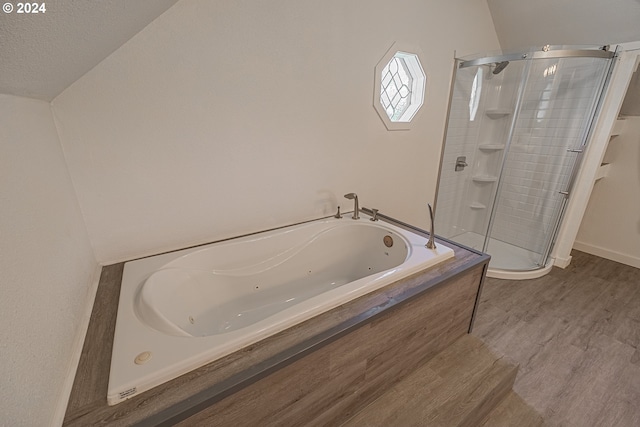 bathroom with hardwood / wood-style floors, a textured ceiling, and independent shower and bath