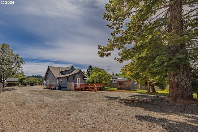 view of property exterior with a storage shed and a wooden deck