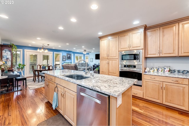 kitchen with sink, an island with sink, plenty of natural light, and appliances with stainless steel finishes