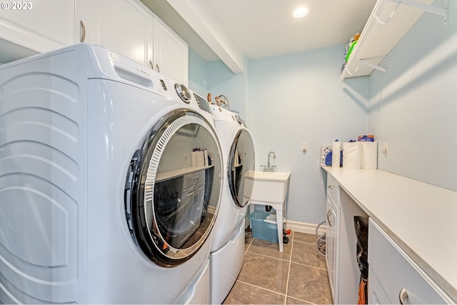 laundry area with cabinets, light tile patterned floors, and washing machine and clothes dryer