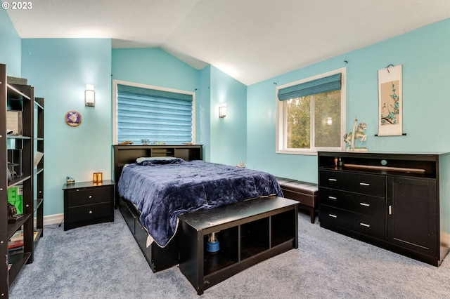 bedroom with light colored carpet and vaulted ceiling