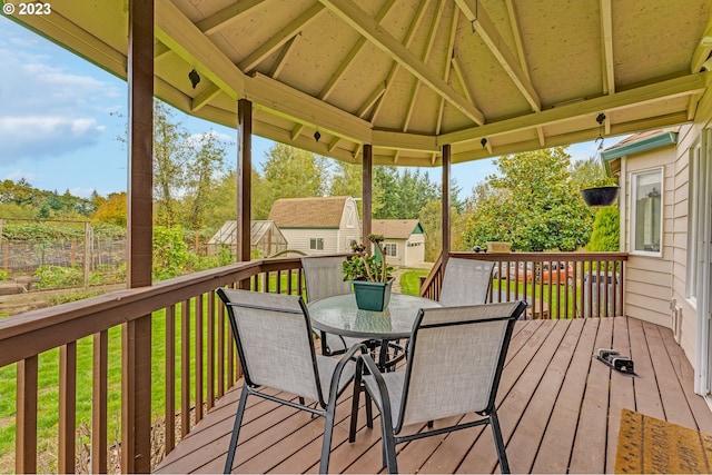 wooden terrace featuring a gazebo, a yard, and a storage shed