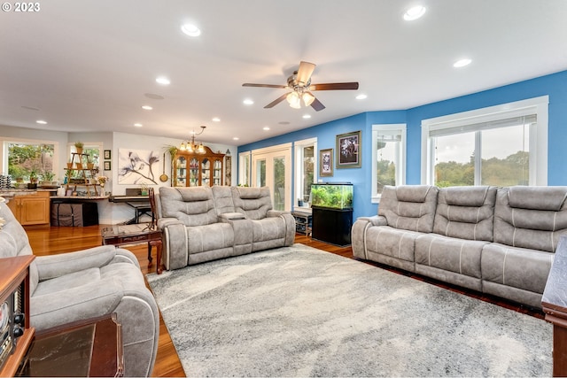 living room featuring hardwood / wood-style floors and ceiling fan with notable chandelier