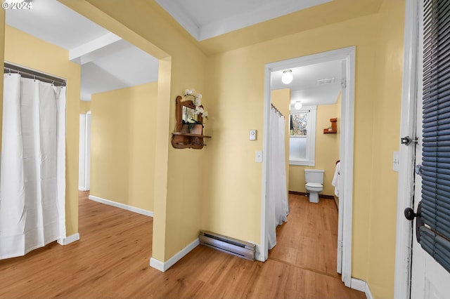 corridor featuring light wood-type flooring and a baseboard heating unit