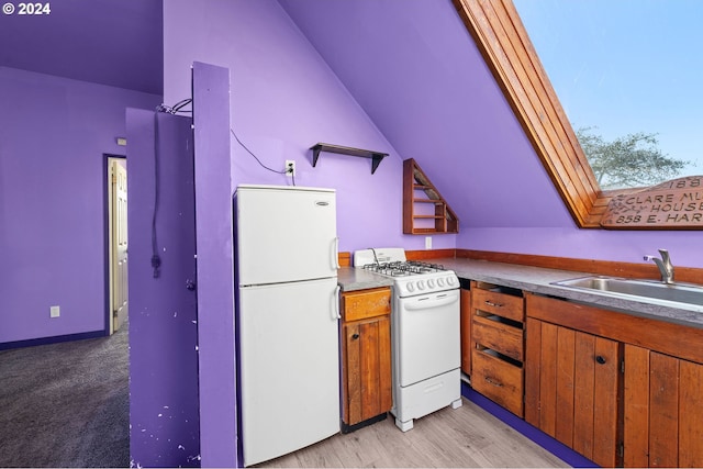 kitchen with vaulted ceiling with skylight, light wood-type flooring, sink, and white appliances