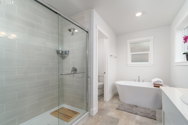 full bathroom featuring vanity, shower with separate bathtub, and toilet