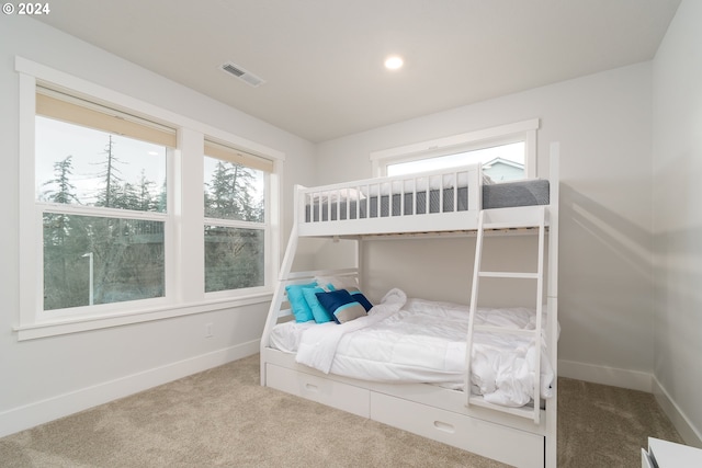 bedroom with multiple windows and light carpet