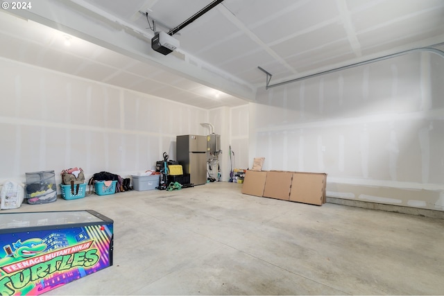 garage featuring a garage door opener and stainless steel refrigerator