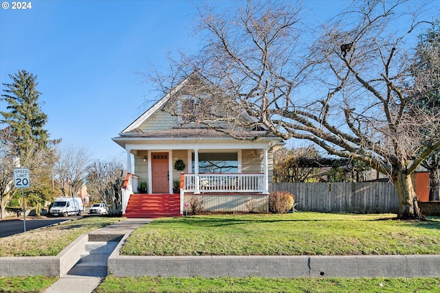 view of front of house with covered porch and a front yard