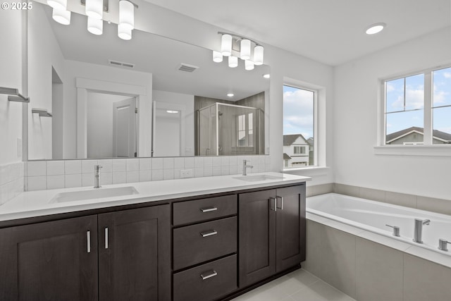 bathroom featuring tile patterned floors, vanity, shower with separate bathtub, and backsplash