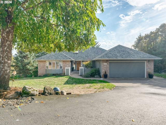 14355 NW Pheasant Hill Ln, Mcminnville, OR 97128 - single story home featuring an attached garage, asphalt driveway, brick siding, a front yard, and roof with shingles