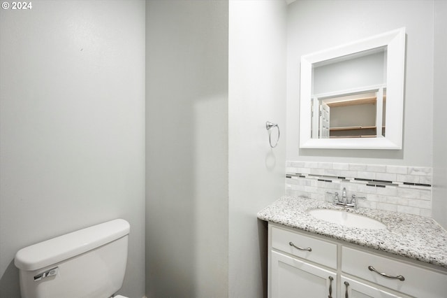 bathroom featuring backsplash, vanity, and toilet