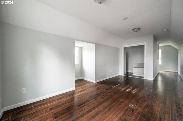 interior space with dark hardwood / wood-style flooring and vaulted ceiling