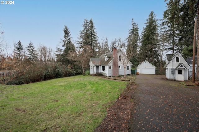 view of front of property with a front lawn, an outdoor structure, and a garage