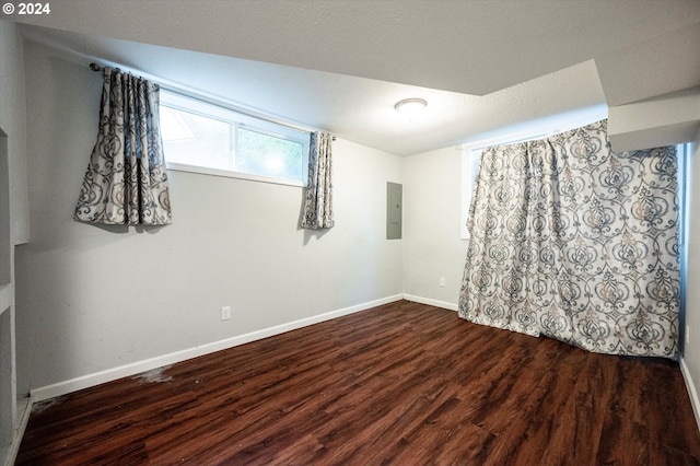 spare room with dark hardwood / wood-style flooring and electric panel