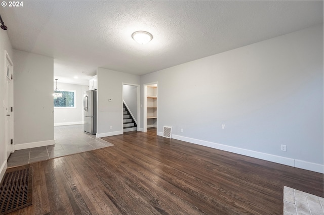 empty room with hardwood / wood-style floors and a textured ceiling