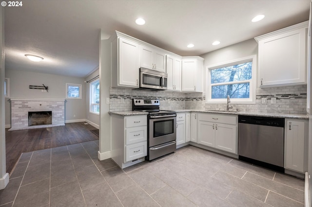 kitchen with light tile patterned flooring, stainless steel appliances, white cabinetry, and sink