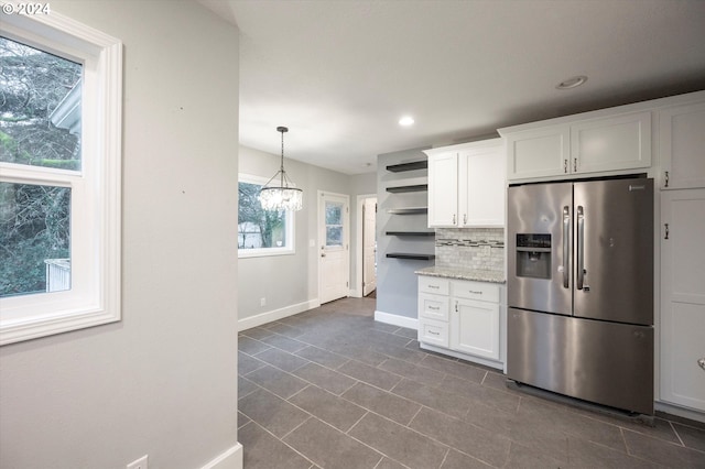 kitchen with decorative backsplash, stainless steel fridge with ice dispenser, white cabinetry, and plenty of natural light