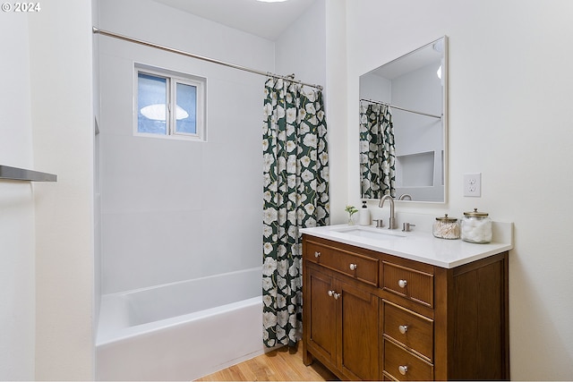 bathroom with hardwood / wood-style flooring, shower / bath combo, and vanity