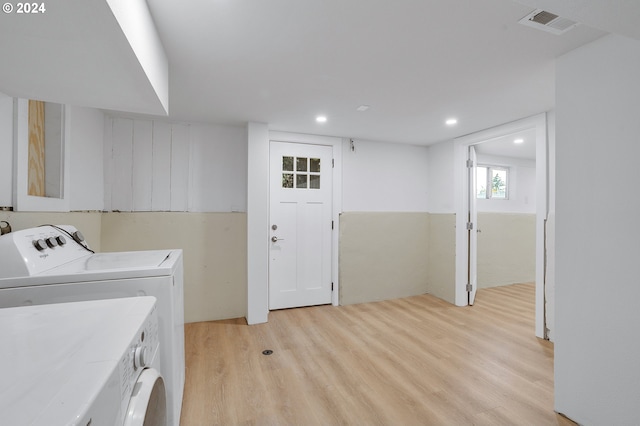 laundry area featuring washer and dryer and light hardwood / wood-style flooring