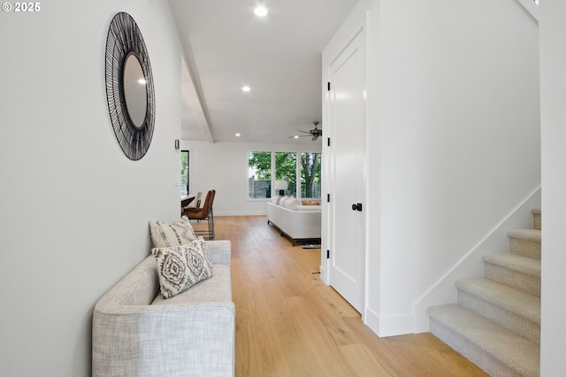 hall with stairs, recessed lighting, baseboards, and light wood-style flooring
