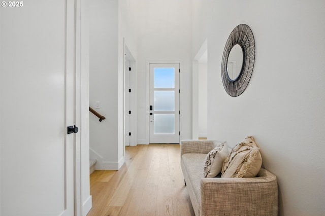interior space with light wood-style floors, baseboards, and stairs