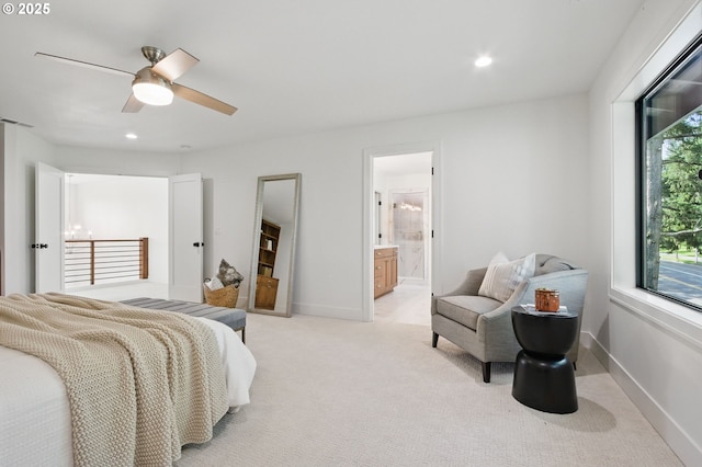 bedroom with recessed lighting, connected bathroom, baseboards, and light colored carpet