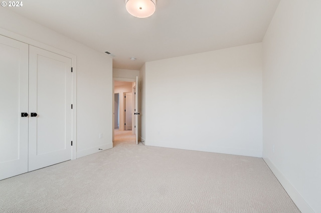 unfurnished bedroom featuring carpet floors, baseboards, and a closet
