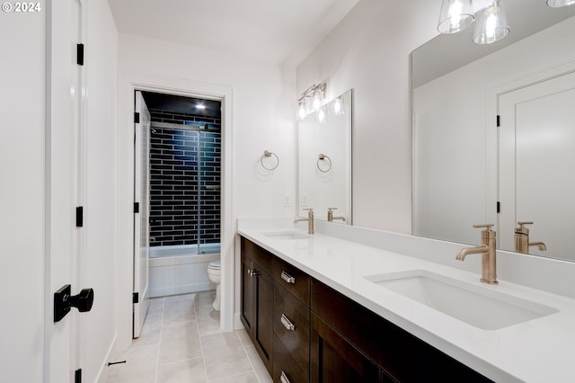 bathroom with double vanity, toilet, tile patterned floors, and a sink