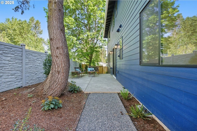 view of side of property featuring a fenced backyard and a patio area