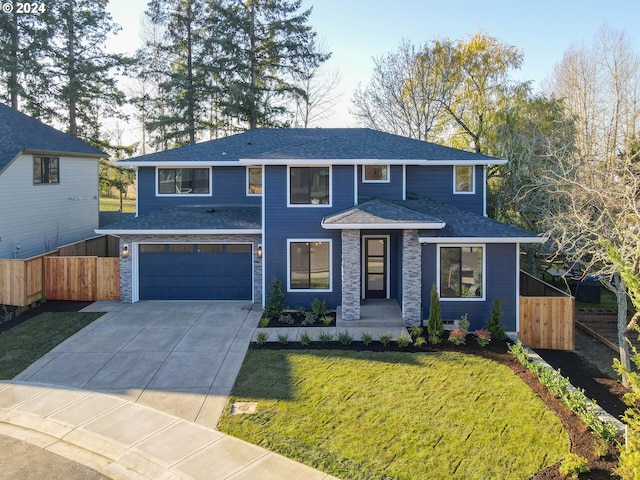 prairie-style home featuring concrete driveway, an attached garage, fence, and a front lawn