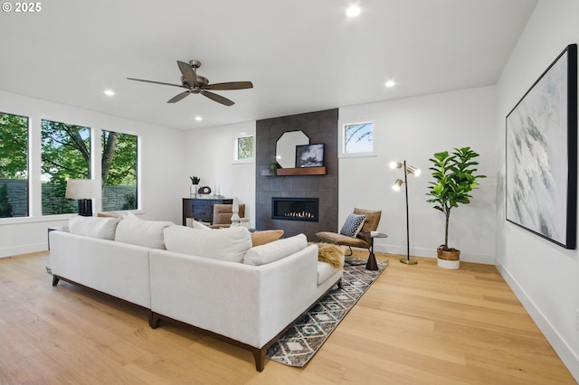 living area featuring light wood-type flooring, plenty of natural light, and a fireplace