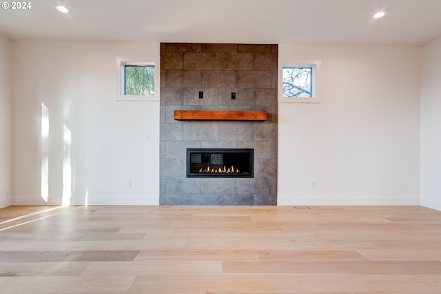 unfurnished living room featuring light wood-type flooring and a fireplace