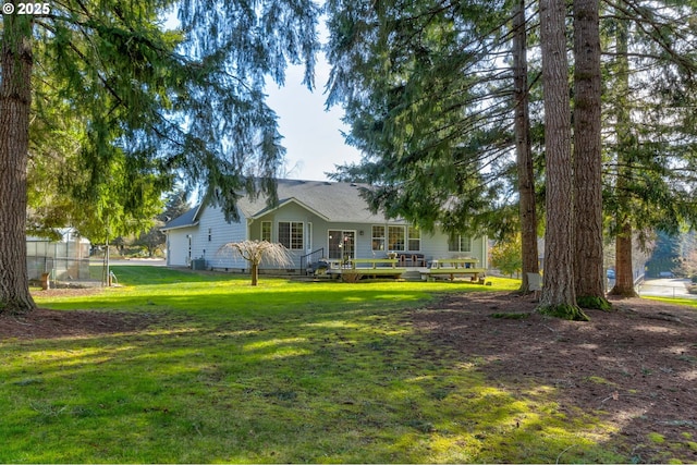 exterior space with a wooden deck and a front yard