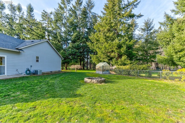 view of yard featuring cooling unit, a fire pit, and an outdoor structure