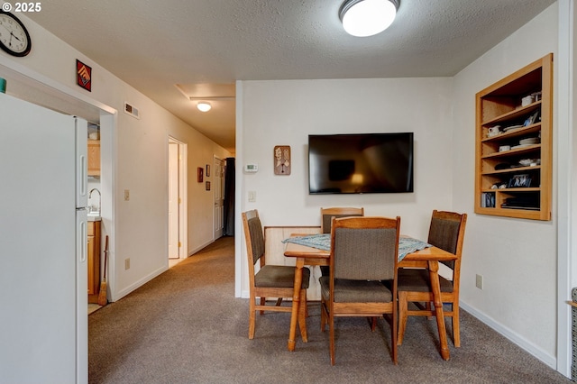 dining room featuring a textured ceiling and carpet