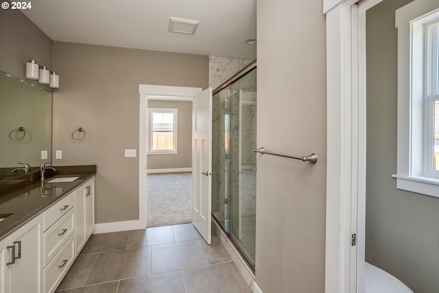 bathroom featuring tile patterned flooring, walk in shower, and vanity