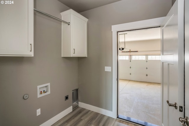 washroom featuring cabinets, hookup for a washing machine, hookup for an electric dryer, and light hardwood / wood-style floors