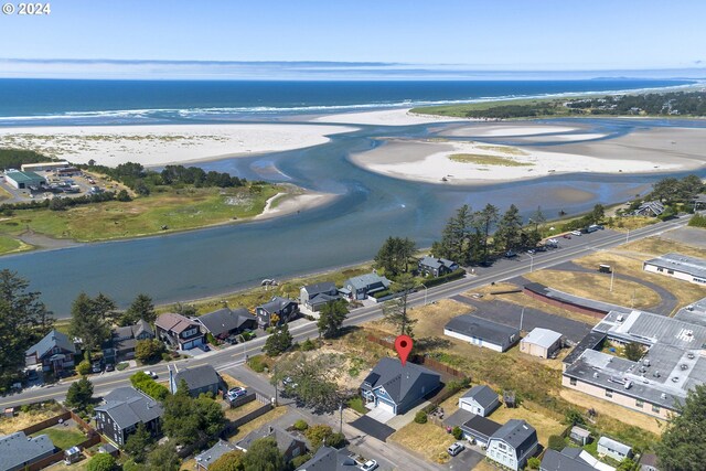 birds eye view of property with a water view and a view of the beach