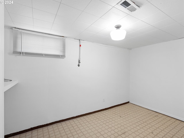 below grade area featuring light floors, visible vents, and baseboards