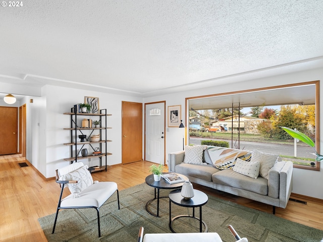 living room featuring a textured ceiling, wood finished floors, and visible vents