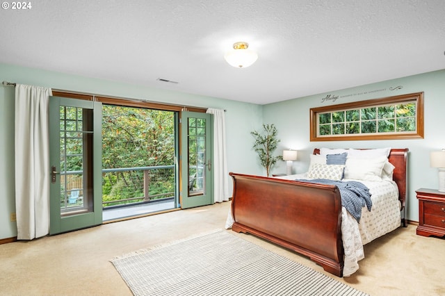 bedroom with light carpet, a textured ceiling, and access to exterior