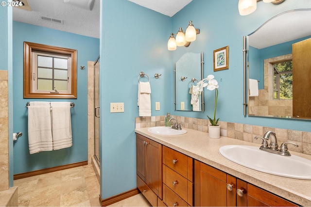 bathroom with decorative backsplash, dual bowl vanity, a textured ceiling, and tile patterned flooring