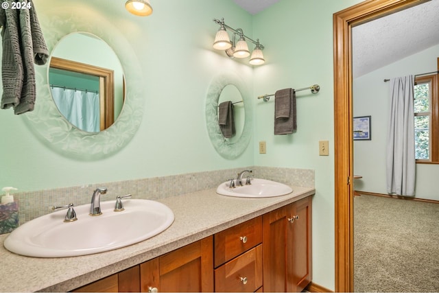 bathroom with vaulted ceiling, a textured ceiling, and double vanity