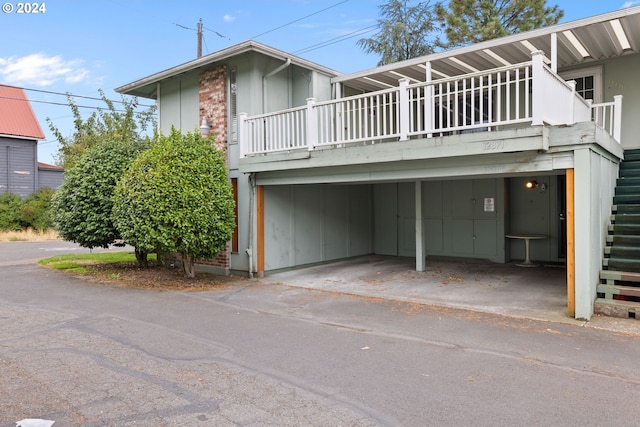 view of front of property with a carport and stairway