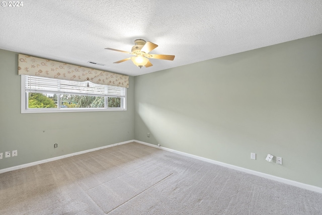 carpeted spare room with a textured ceiling and ceiling fan