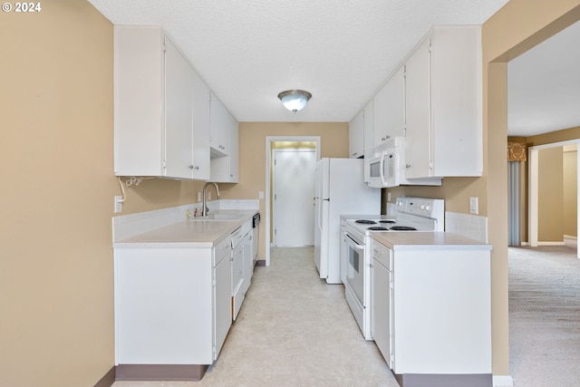 kitchen featuring white cabinets, white appliances, a textured ceiling, and sink