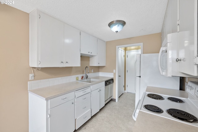 kitchen featuring white appliances, sink, white cabinets, and a textured ceiling