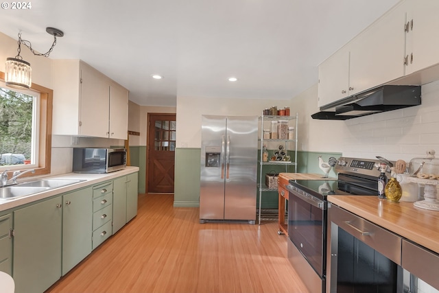 kitchen featuring appliances with stainless steel finishes, tasteful backsplash, white cabinetry, and sink