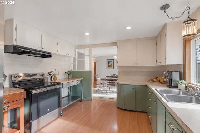 kitchen featuring light wood-type flooring, sink, pendant lighting, electric range, and white cabinets